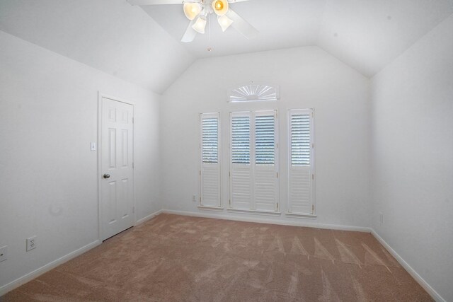 carpeted spare room featuring ceiling fan and vaulted ceiling