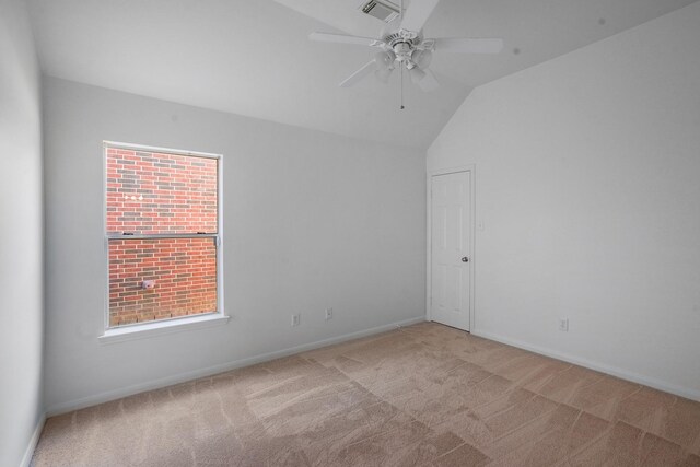 empty room with lofted ceiling, light colored carpet, and ceiling fan