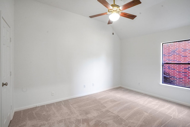 carpeted spare room featuring ceiling fan and lofted ceiling