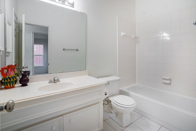 full bathroom with tile patterned flooring, vanity, tiled shower / bath, and toilet