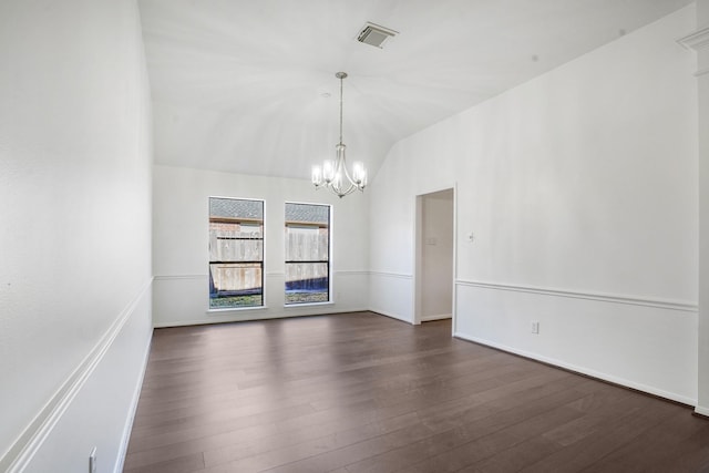 empty room featuring an inviting chandelier, lofted ceiling, and dark hardwood / wood-style flooring