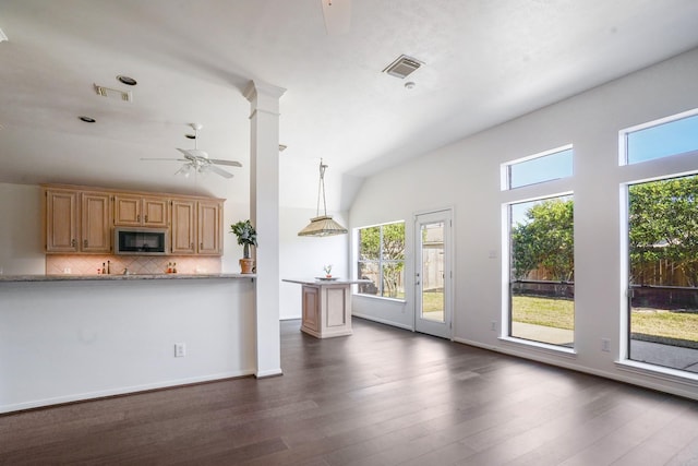 kitchen featuring lofted ceiling, decorative light fixtures, dark hardwood / wood-style flooring, ceiling fan, and backsplash