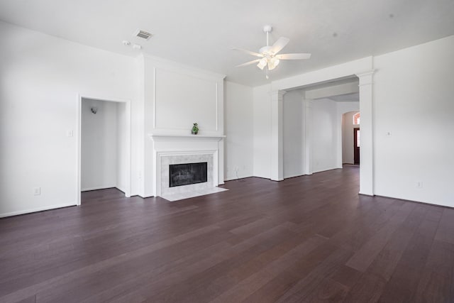 unfurnished living room with dark wood-type flooring, ceiling fan, and a premium fireplace