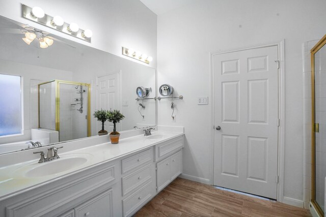 bathroom featuring a shower with door, vanity, hardwood / wood-style floors, and ceiling fan