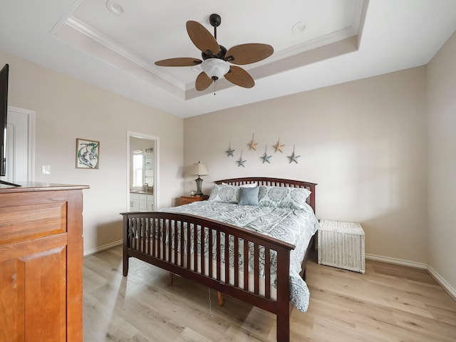 bedroom with a raised ceiling, crown molding, and light hardwood / wood-style floors