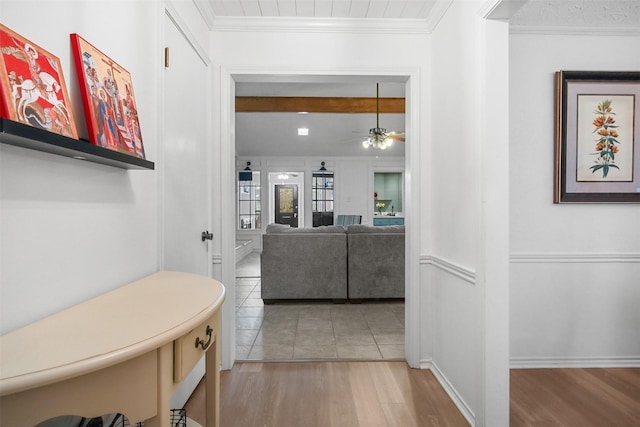 corridor featuring ornamental molding and light hardwood / wood-style floors