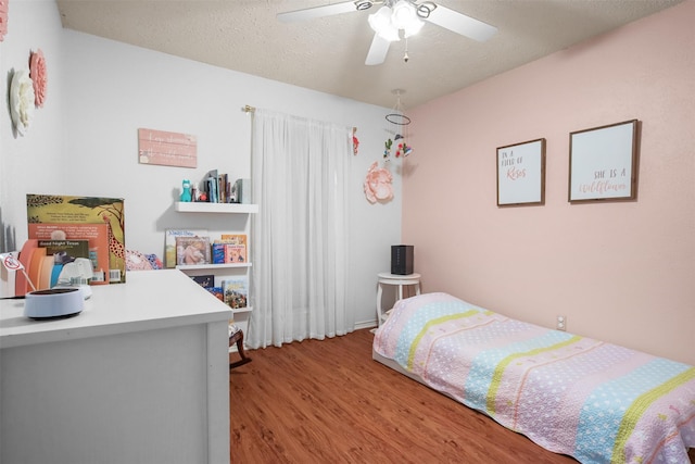 bedroom featuring ceiling fan, light hardwood / wood-style floors, and a textured ceiling