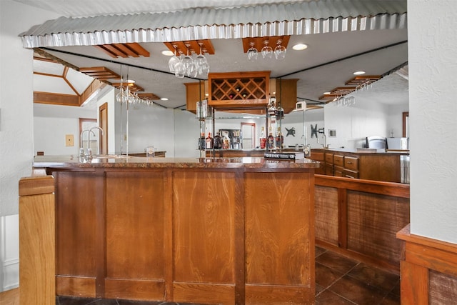 bar featuring dark tile patterned flooring, sink, and a textured ceiling