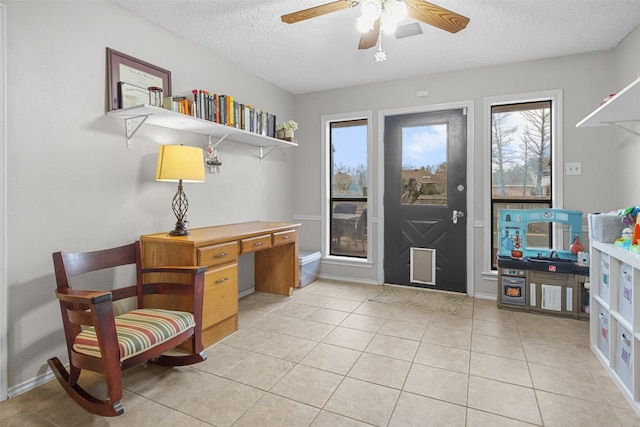 entryway featuring a textured ceiling, light tile patterned flooring, and ceiling fan