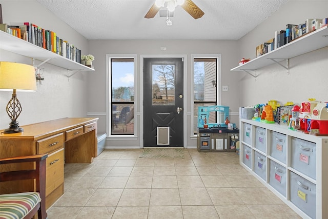 interior space featuring ceiling fan, a textured ceiling, and a healthy amount of sunlight