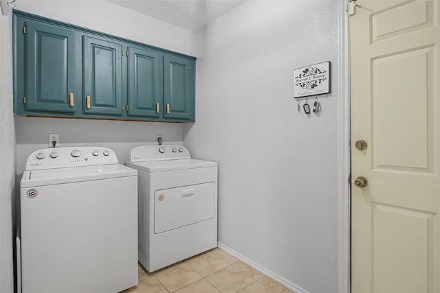 washroom featuring cabinets, light tile patterned floors, separate washer and dryer, and a textured ceiling