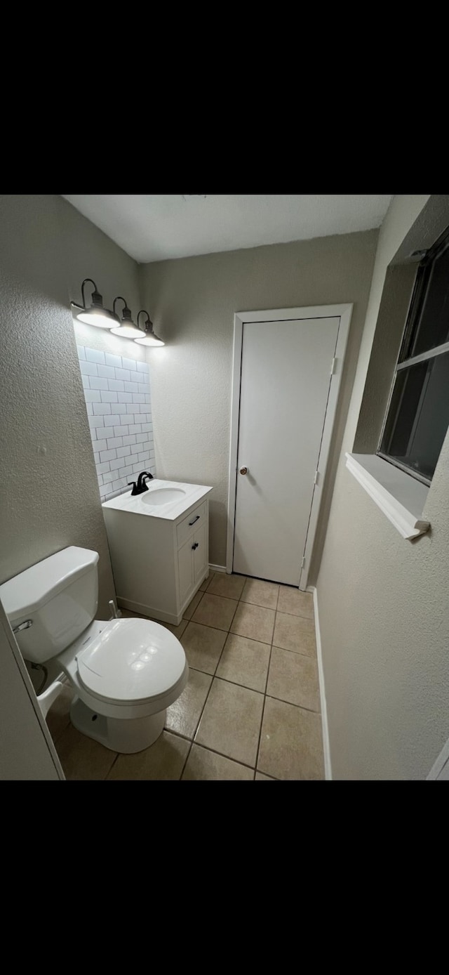 bathroom featuring tile patterned flooring, vanity, and toilet