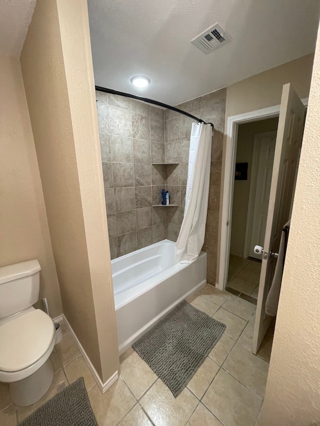 bathroom with shower / bath combination with curtain, tile patterned floors, and toilet