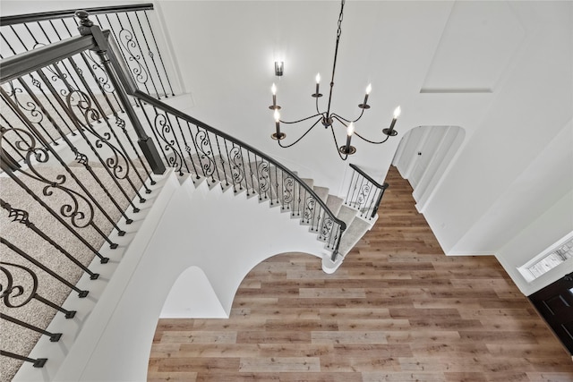 stairs with a chandelier and hardwood / wood-style floors