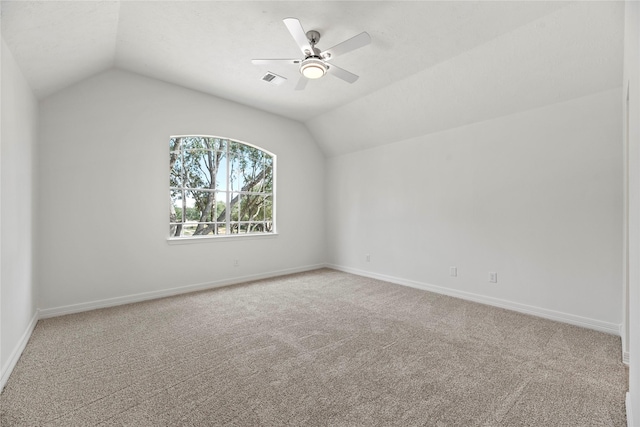 carpeted spare room featuring ceiling fan, lofted ceiling, and a textured ceiling