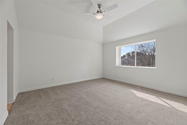 carpeted spare room featuring lofted ceiling and ceiling fan