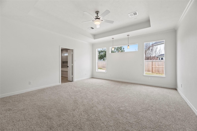 spare room featuring ceiling fan, light colored carpet, a tray ceiling, and crown molding