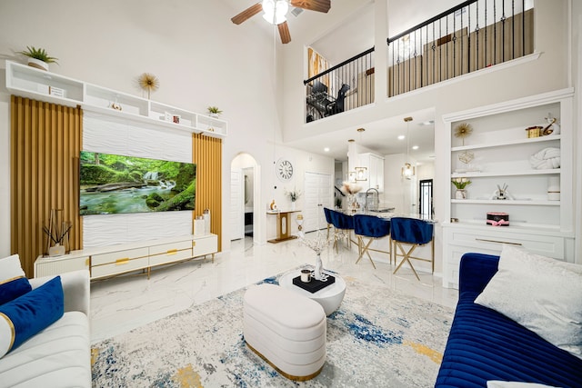 living room with sink, ceiling fan, and built in shelves