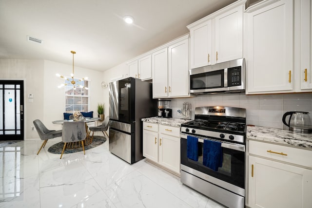 kitchen with white cabinetry, decorative light fixtures, and stainless steel appliances