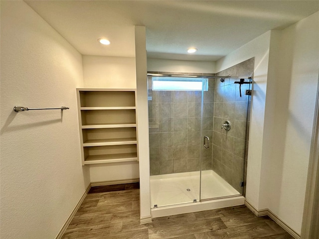 bathroom with hardwood / wood-style flooring and a shower with door