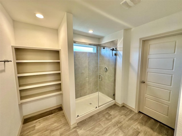 bathroom featuring walk in shower and wood-type flooring