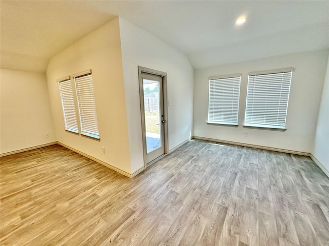 empty room with lofted ceiling and light wood-type flooring