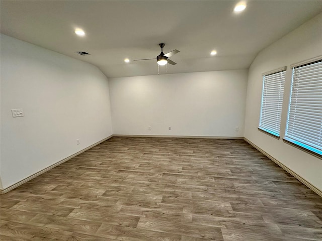 spare room with ceiling fan, lofted ceiling, and light wood-type flooring