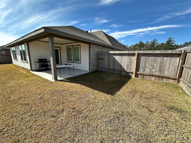 back of property with a yard and a patio