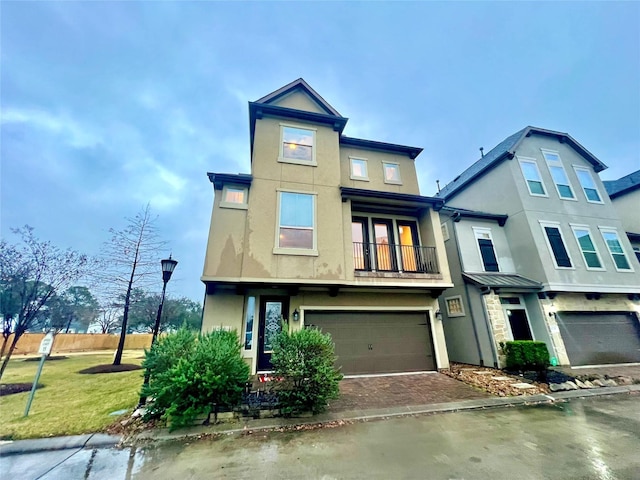 view of front of house featuring a balcony, a garage, and a front lawn