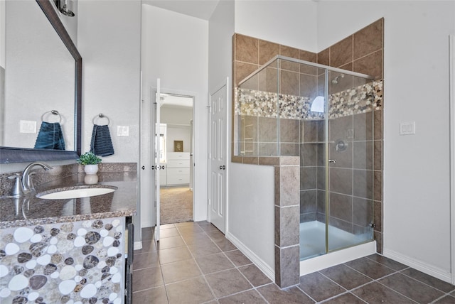 bathroom with vanity, a shower with shower door, and tile patterned floors