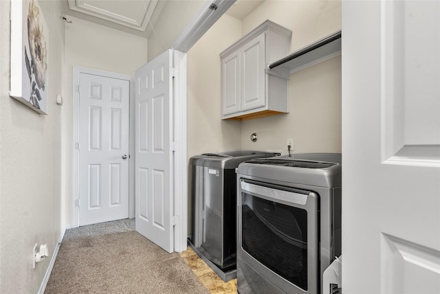 washroom featuring cabinets, washer and clothes dryer, and light carpet