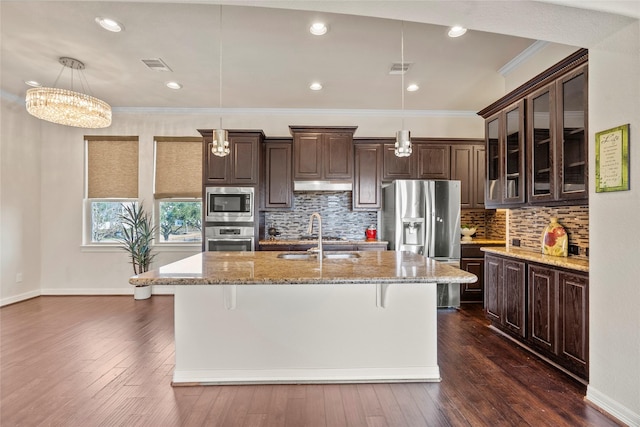 kitchen featuring pendant lighting, stainless steel appliances, sink, and dark brown cabinets