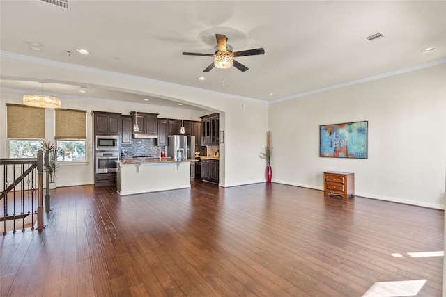 unfurnished living room with dark wood-type flooring, ornamental molding, and ceiling fan