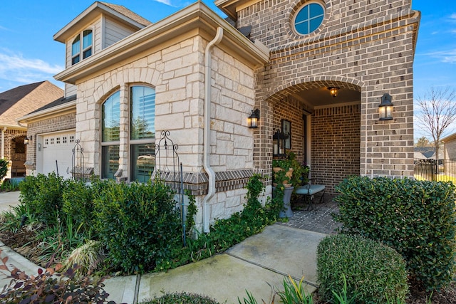 12169 Creekside Villas Ct, Conroe, TX 77304 - entrance to property with an attached garage, brick siding, and stone siding