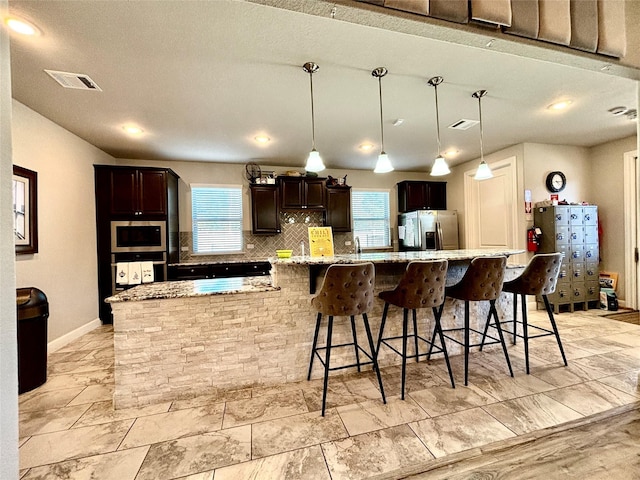 12169 Creekside Villas Ct, Conroe, TX 77304 - kitchen featuring appliances with stainless steel finishes, healthy amount of natural light, tasteful backsplash, dark brown cabinets, and recessed lighting