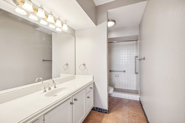 bathroom with tiled shower, vanity, toilet, and tile patterned floors