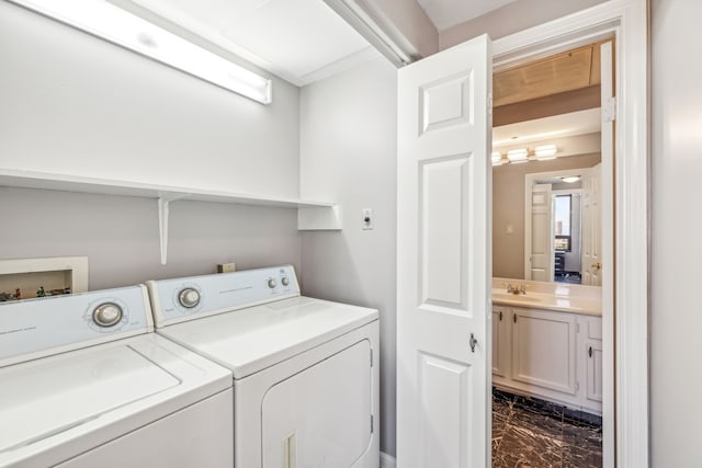 clothes washing area with separate washer and dryer and sink