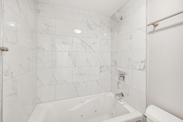 bathroom with toilet and tiled shower / bath combo