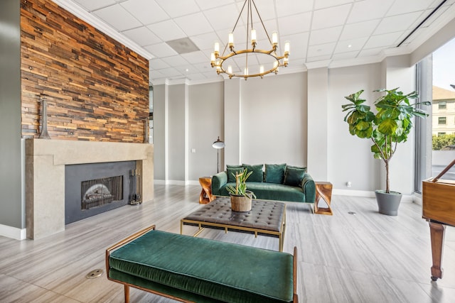 living room with crown molding, a paneled ceiling, and a chandelier