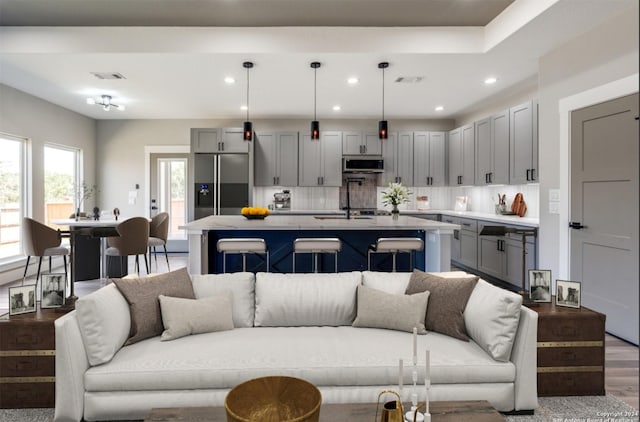 living area with wood finished floors, visible vents, and recessed lighting