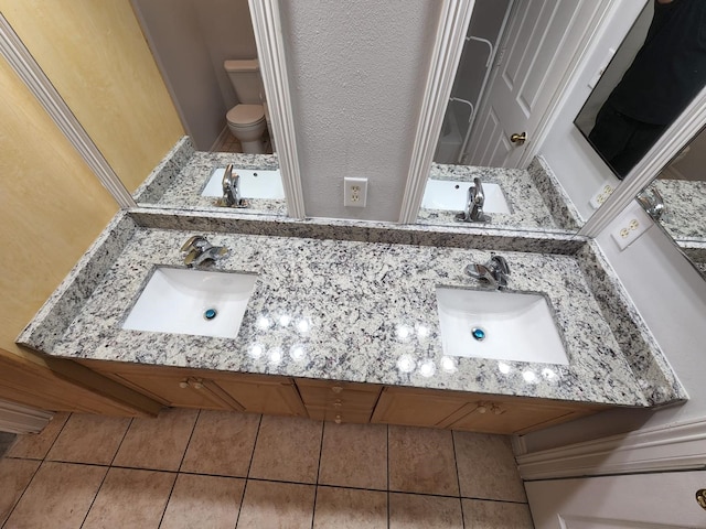 bathroom featuring vanity, tile patterned flooring, and toilet