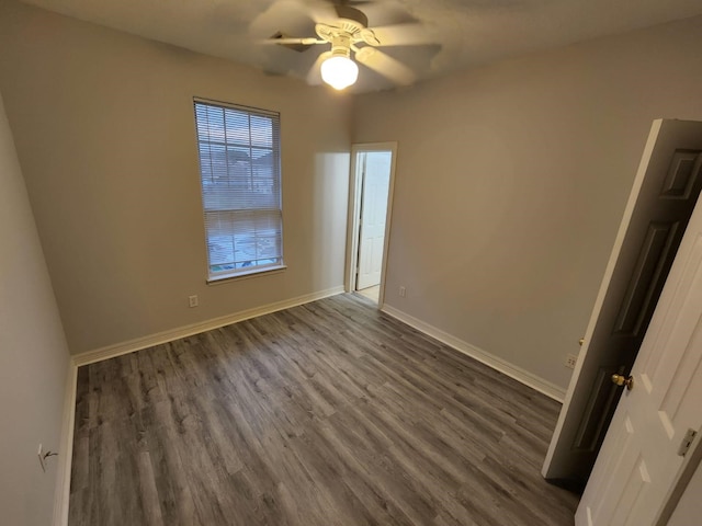 empty room with dark wood-type flooring and ceiling fan