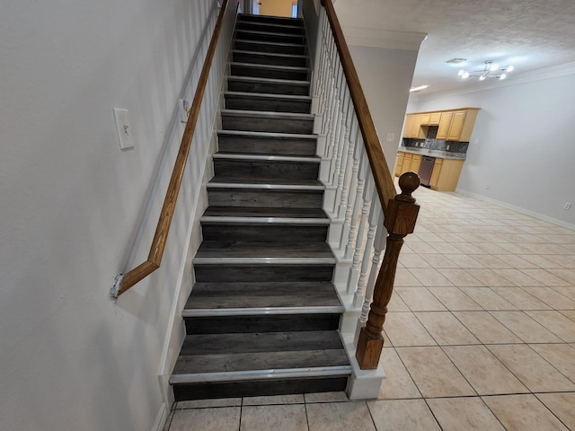 stairs with ornamental molding, tile patterned floors, and a textured ceiling