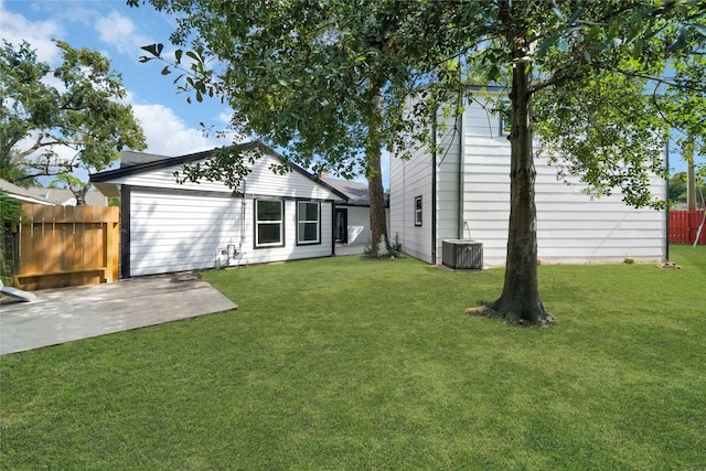 rear view of house featuring a patio, central air condition unit, and a lawn