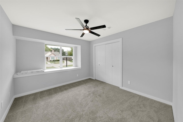 unfurnished bedroom featuring carpet floors, ceiling fan, and a closet