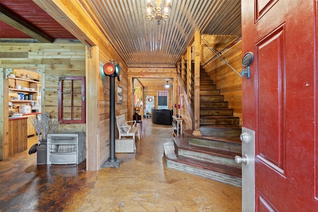 entrance foyer with wood ceiling, stairs, and wooden walls