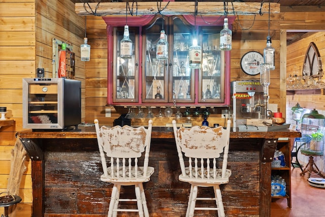 bar with a dry bar, wine cooler, wooden walls, and decorative light fixtures