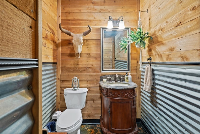 half bath featuring toilet, wood walls, and vanity