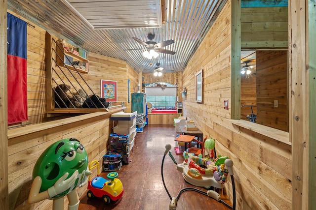 rec room featuring wooden ceiling, a ceiling fan, and wooden walls