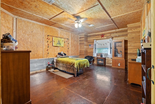 bedroom featuring cooling unit, wooden walls, visible vents, and hardwood / wood-style floors